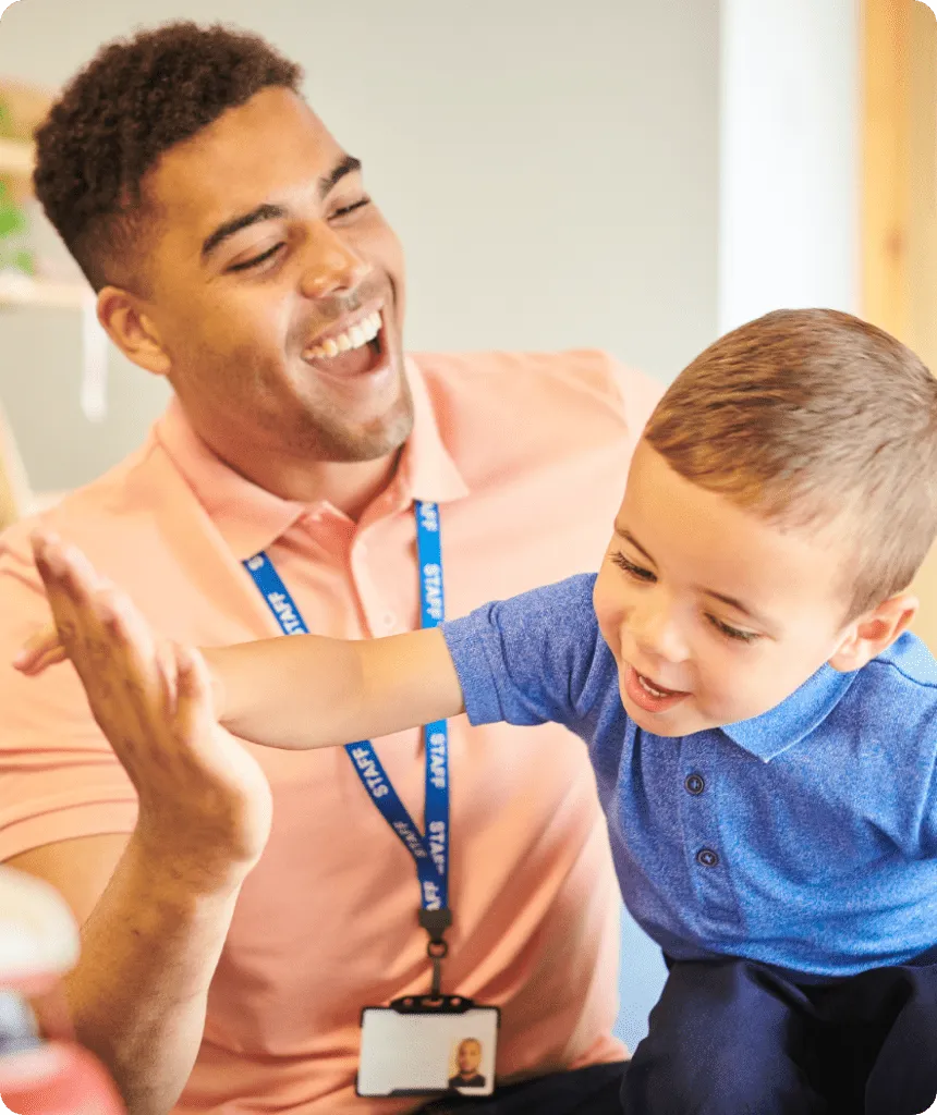 young happy boy giving high five to happy teacher