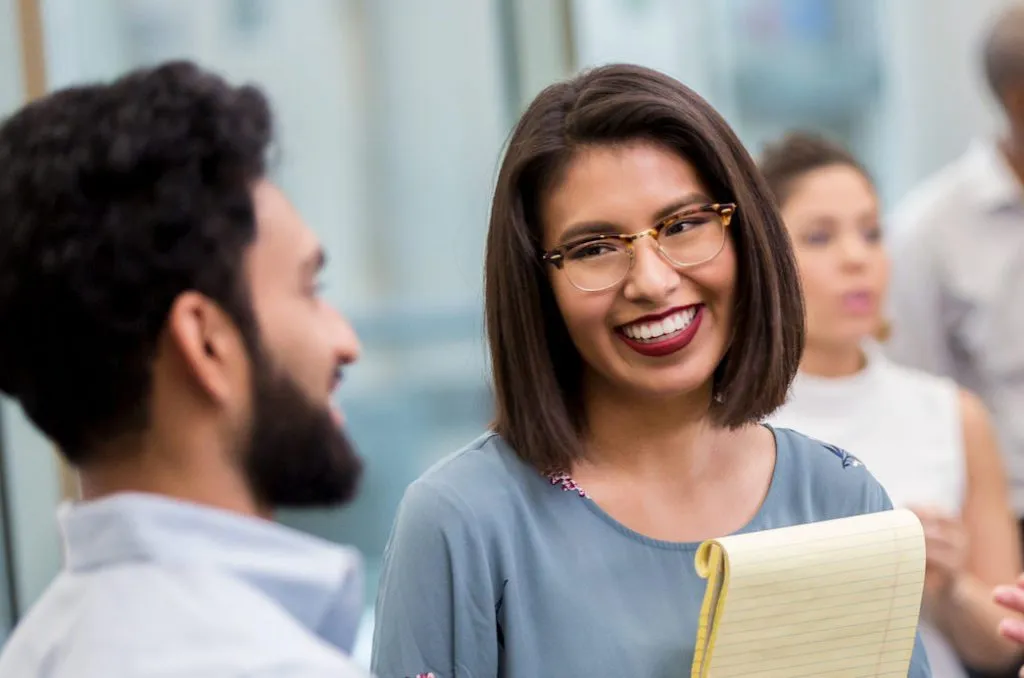 smiling teacher at a conference conversing with peers