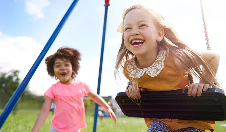 two children enjoying the swings