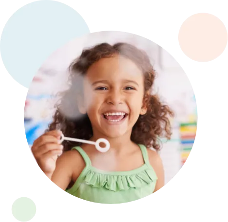 young girl laughing while making bubbles