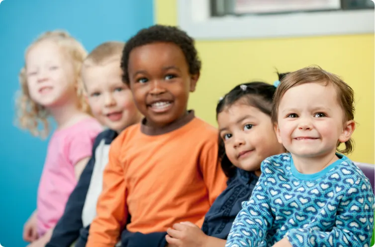 five happy children smiling in the classroom