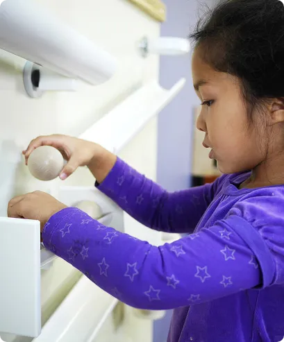 young girl in classroom enjoying kodo's magnetic board