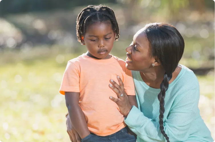 mother consoling daughter outdoors