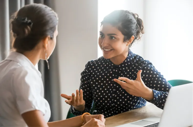 two teachers conversing in a classroom