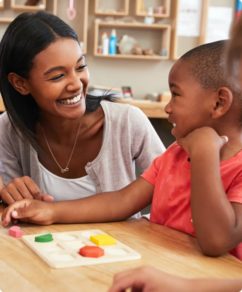 teacher with child using wooden shapes in class