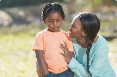 mother consoling sad daughter in a park