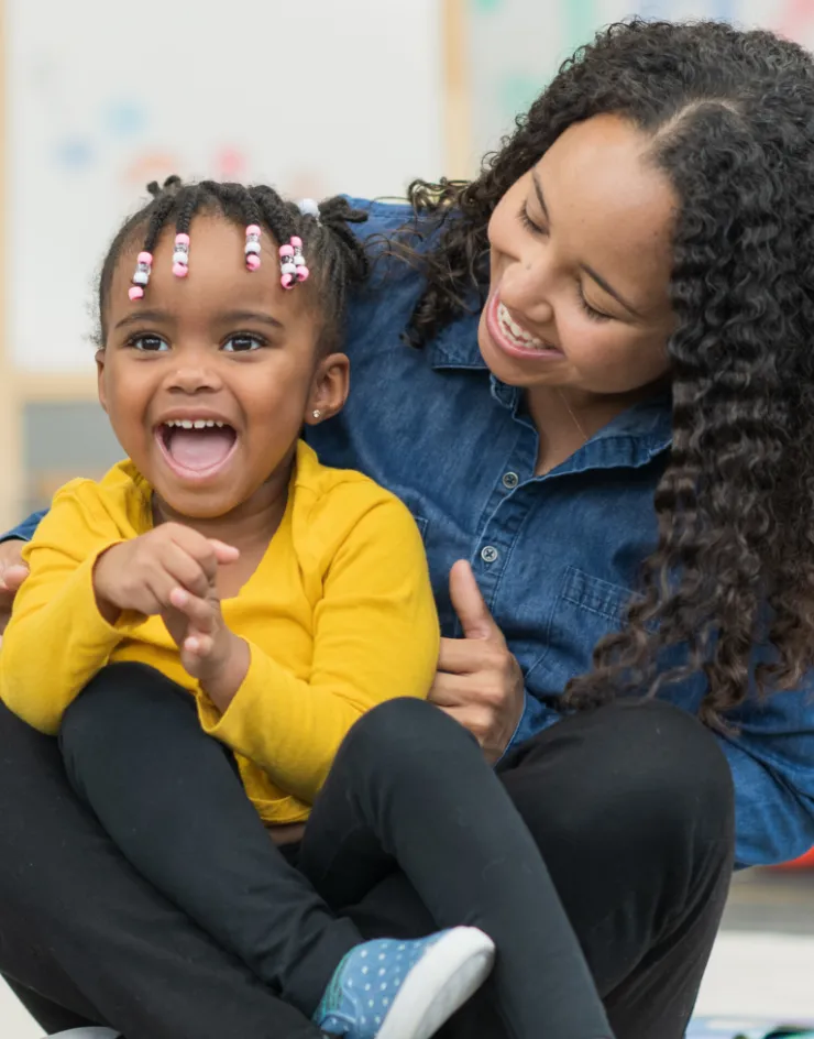 Teacher and child in classroom laughing