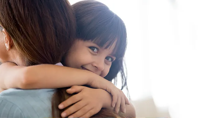 child being carried by a parent smiling